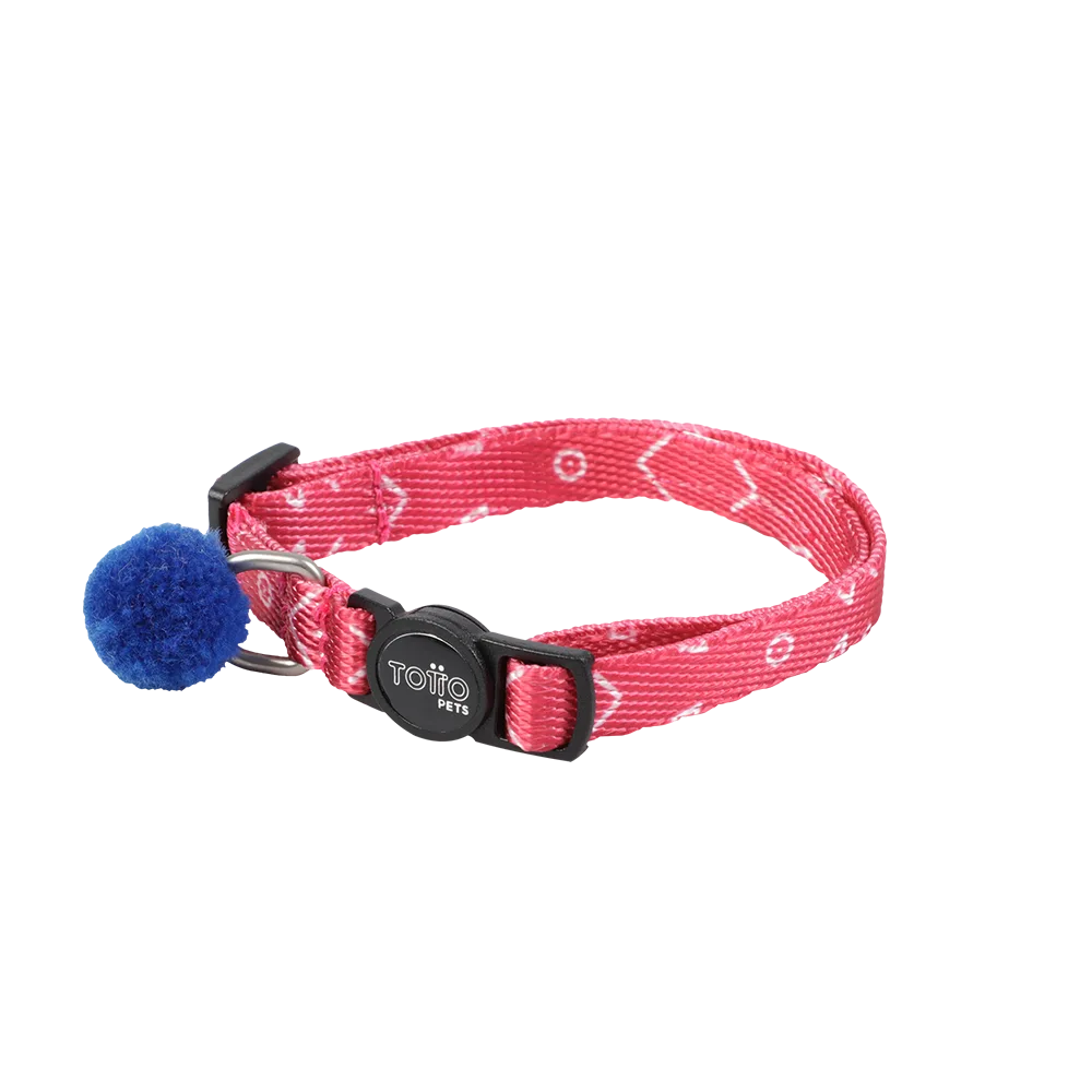 Imagen de collar Meow de la marca Totto, es un collar para gatos color rojo claro con detalles blancos una hebilla plástica negra y una argolla de metal donde le cuelga un pompom azul