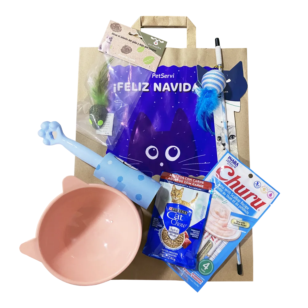 Bolsa de papel kraft con un adhesivo con un diseño de un gato azul y un menasje que dice "Feliz Navidad" Delante hay un empaque de Snack Churu, una cañita para gatos con pelota, plato elevado para gatos color rosado, un alimento húmedo, un roller quita pelusa y un ratón con catnip encapsulado.