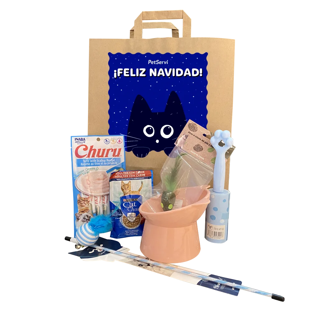 Bolsa de papel kraft con un adhesivo con un diseño de un gato azul y un menasje que dice "Feliz Navidad" Delante hay un empaque de Snack Churu, una cañita para gatos con pelota, plato elevado para gatos color rosado, un alimento húmedo, un roller quita pelusa y un ratón con catnip encapsulado.