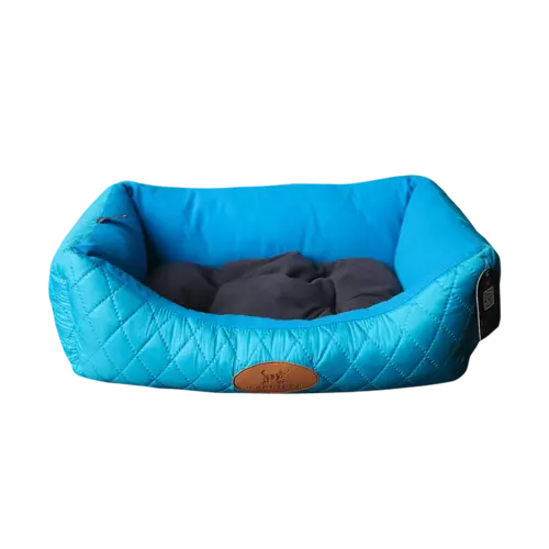 Cama para mascotas acolchada en color azul brillante con bordes elevados y una placa decorativa