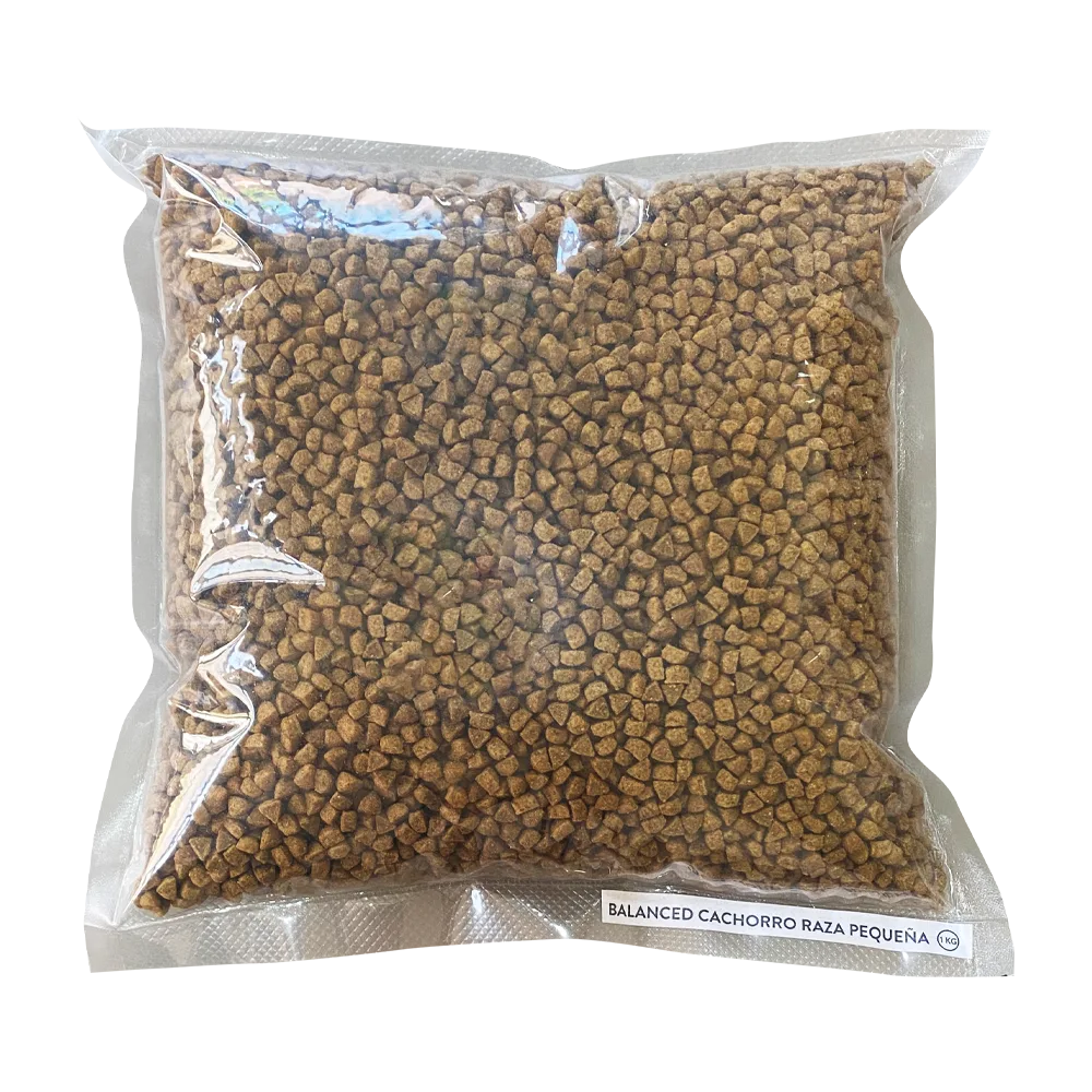 Bolsa transparente de croquetas color marrón del alimento Balanced Cachorro Raza Pequeña en su presentación fraccionada de 1 kg