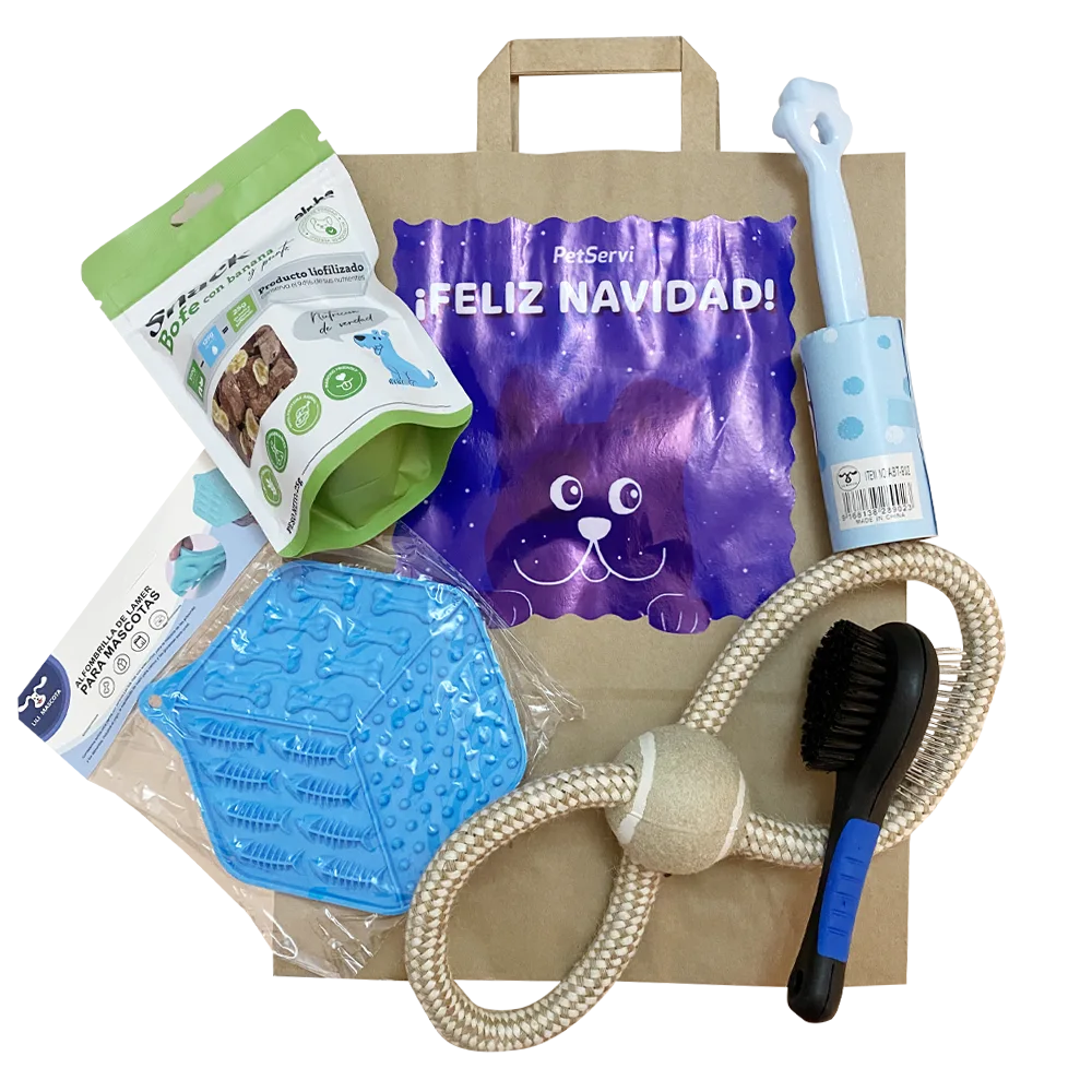 Bolsa de papel kraft con un diseño de perro color azul que dice "Feliz Navidad" y tiene en frente los siguientes productos: un snack para perros, un cepillo negro, una cuerda con forma de 8 y pelota, un roller para quitar pelusa y un plato de goma.