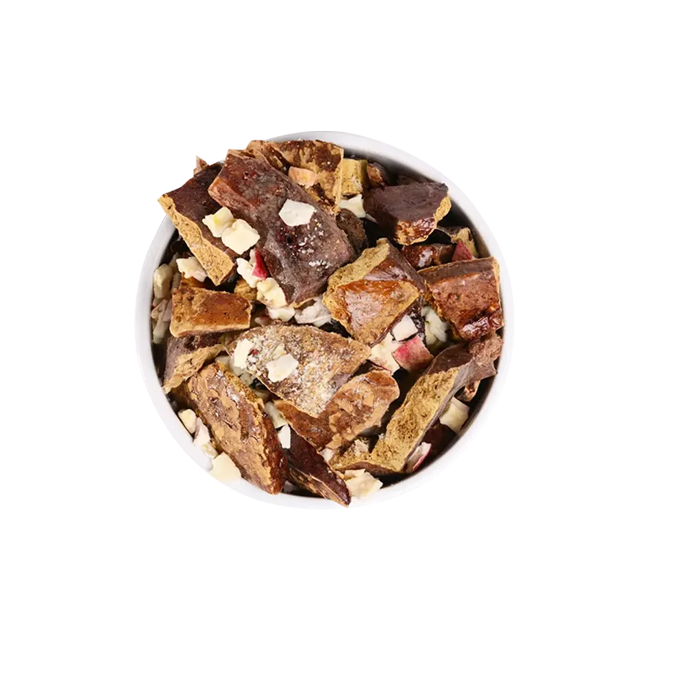 Plato redondo con trozos de hígado y manzana roja liofilizados.