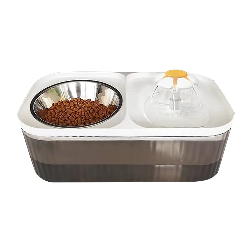 Fuente Automática para mascotas 2 en 1, en un lado tiene una flor por donde sale el agua y circula y en el otro lado tiene un plato de acero inoxidable donde se puede poner croquetas, la base es de color blanco y el cuerpo de un color gris trasnparente.