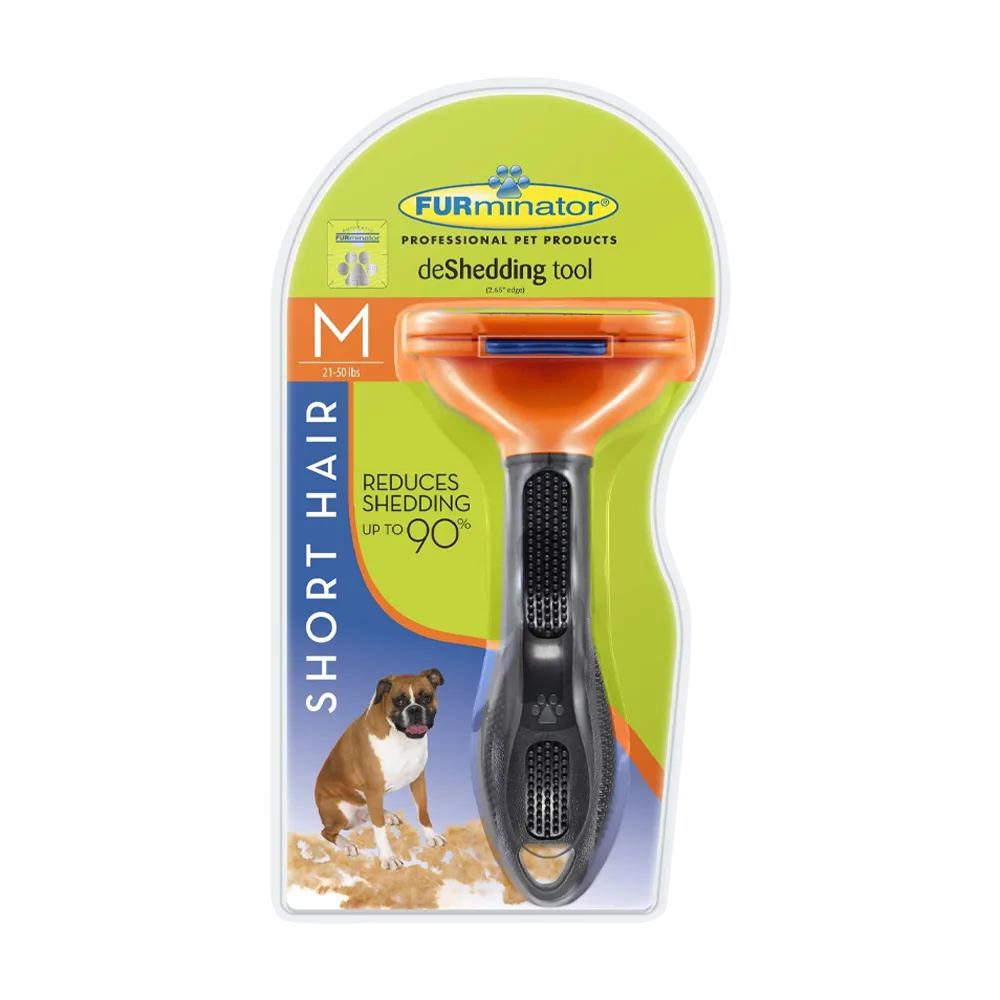Cepillo FURminator para Perros de pelo corto en su empaque original que es de color verde con detalles azules, el cepillo es plástico con un mango negro y la parte superior es naranja. Es un cepillo que elimina el pelo de la capa interior del pelaje en perros de pelo corto en talla M