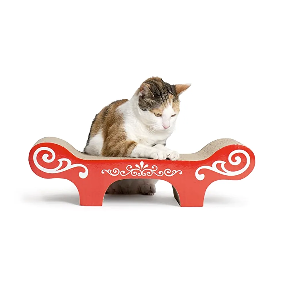 Imagen de rascador tipo banquito, está hecho de cartón corrugado y en la parte frontal tiene un patrón blanco sobre un fondo rojo. Es el Rascador Para Gatos Rojo de la línea Catit. Tiene un gato encima color blanco con manchas marrones