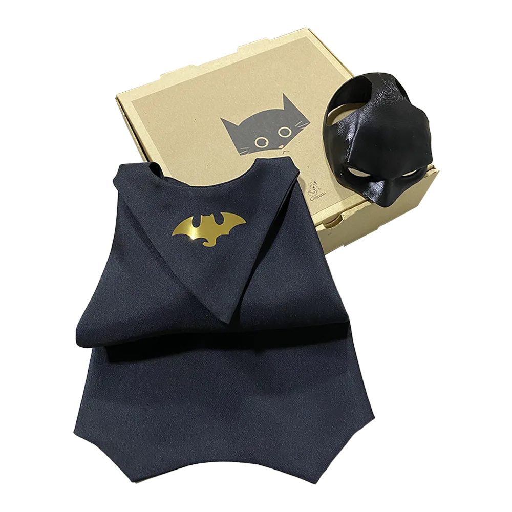Caja de disfraz de Batman para gatos: Batcat Box de la marca boliviana Catllejera. Es una caja de cartón con una máscara de Batman adaptada para gatos y una capa negra de Batman.